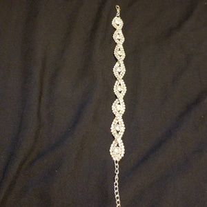 Silver tone bracelet with white stones.